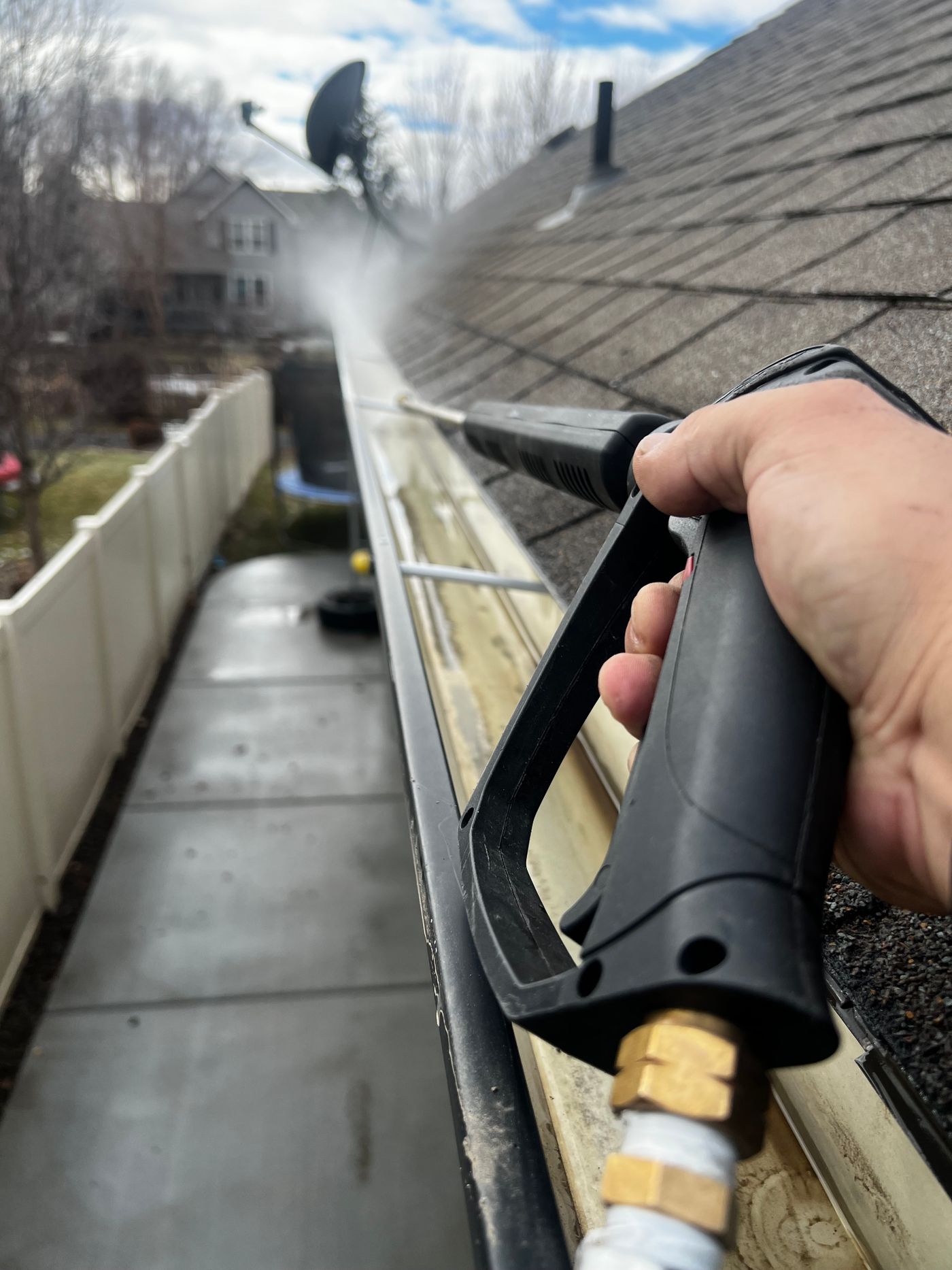 Close view of gutter and roof edge being cleaned